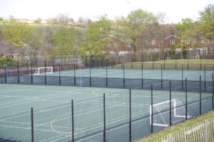 Two Netball courts outside Leigh Academy Longfield with metal fences surrounding them.