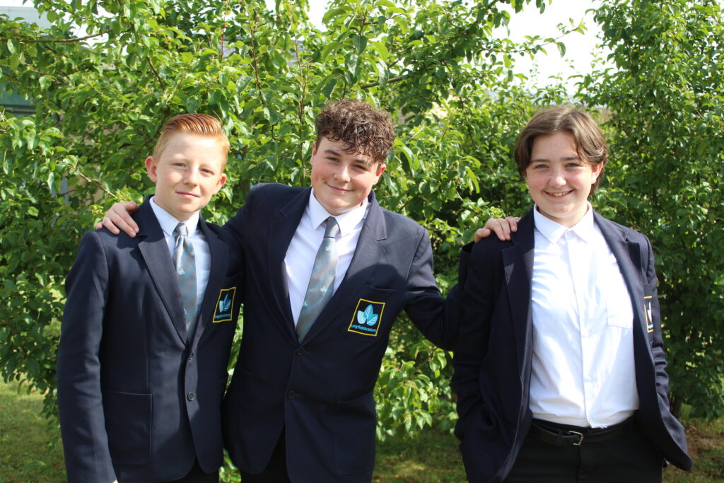3 male students in Leigh Academy Longfield uniform stood outside in front of a tree smiling for a photo
