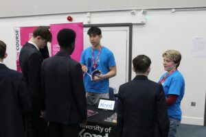Students speaking to 2 people at a University of Kent stall