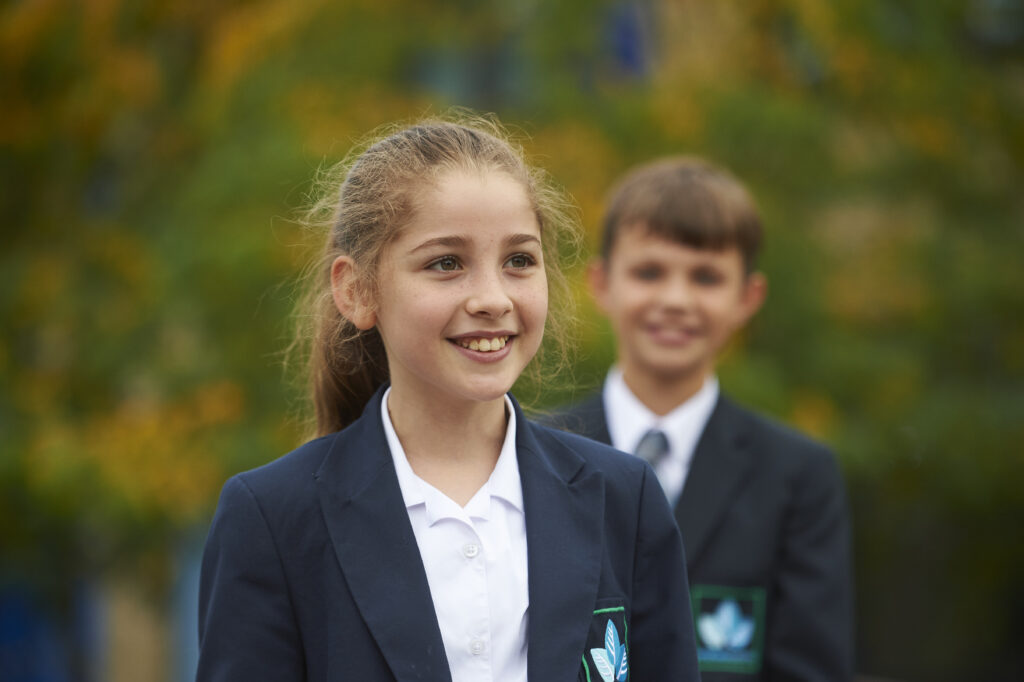 Student looking off to the right with another student in the background facing the camera