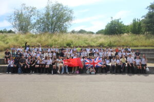 group of students standing outside holding a chinese flag